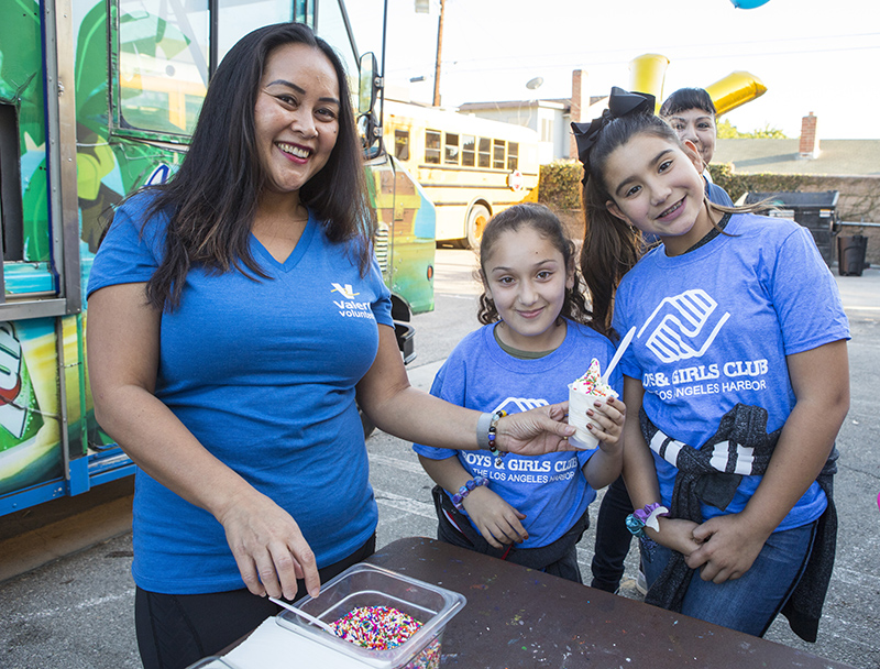 A Valero mentor stands with school children during a volunteer event