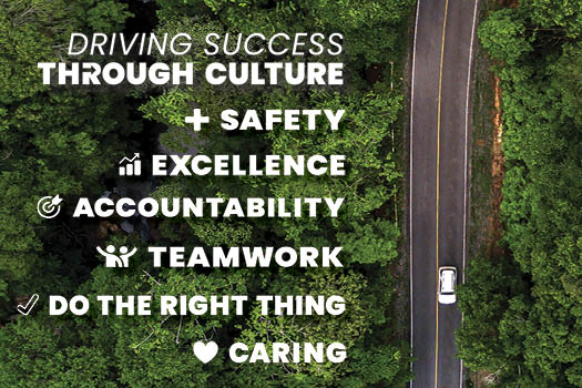 In the background, a top-down image of a car driving through a forest. In the foreground, text reads: "Driving Success Through Culture. Safety. Excellence. Accountability. Teamwork. Do the Right Thing. Caring."