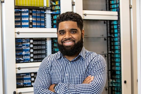 A Valero employee stands in front of computer equipment.