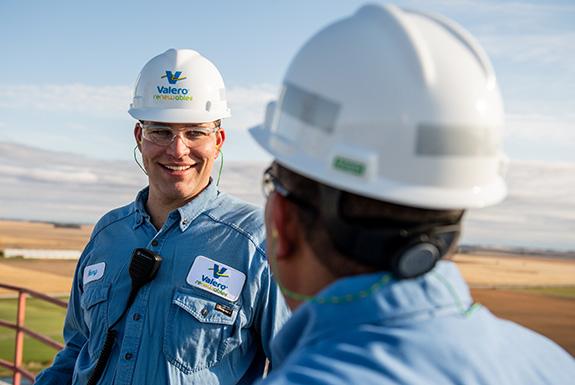 Two employees at a Valero ethanol plant talk together.